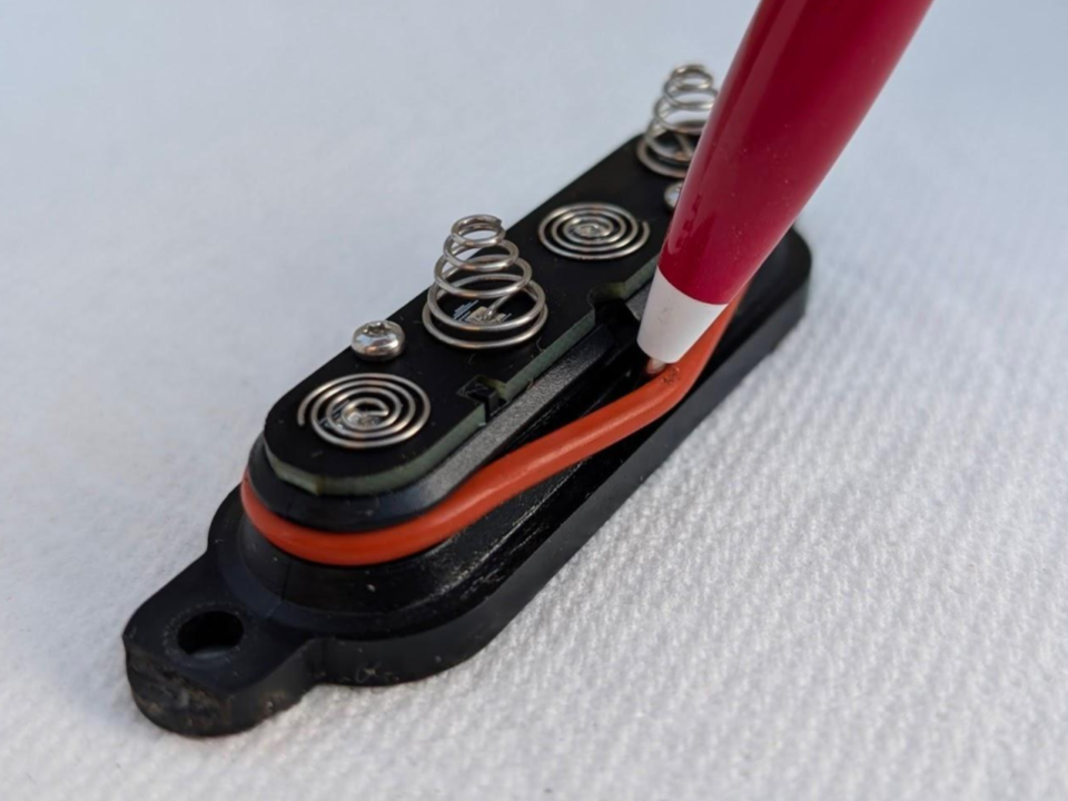 Using a dull pen to gently remove rubber O-ring out of its grrove on battery cap (2 of 2)