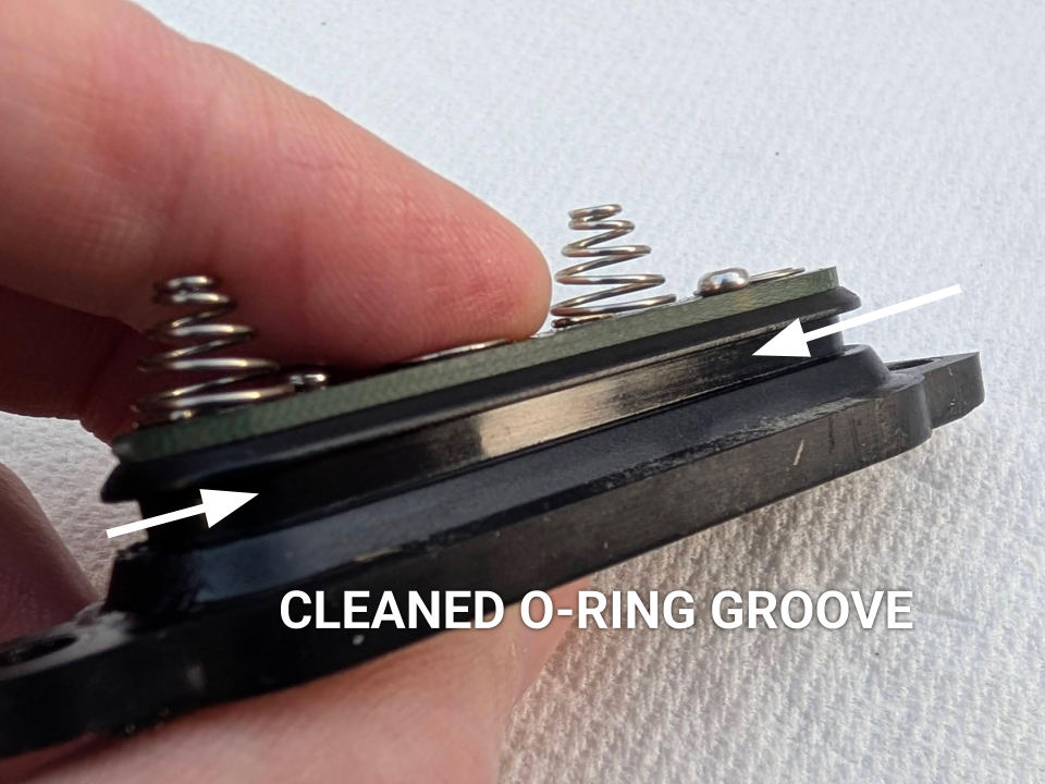 A close-up of battery cap after cleaning, showing a shiny, debris-free groove ready for O-ring re-installation