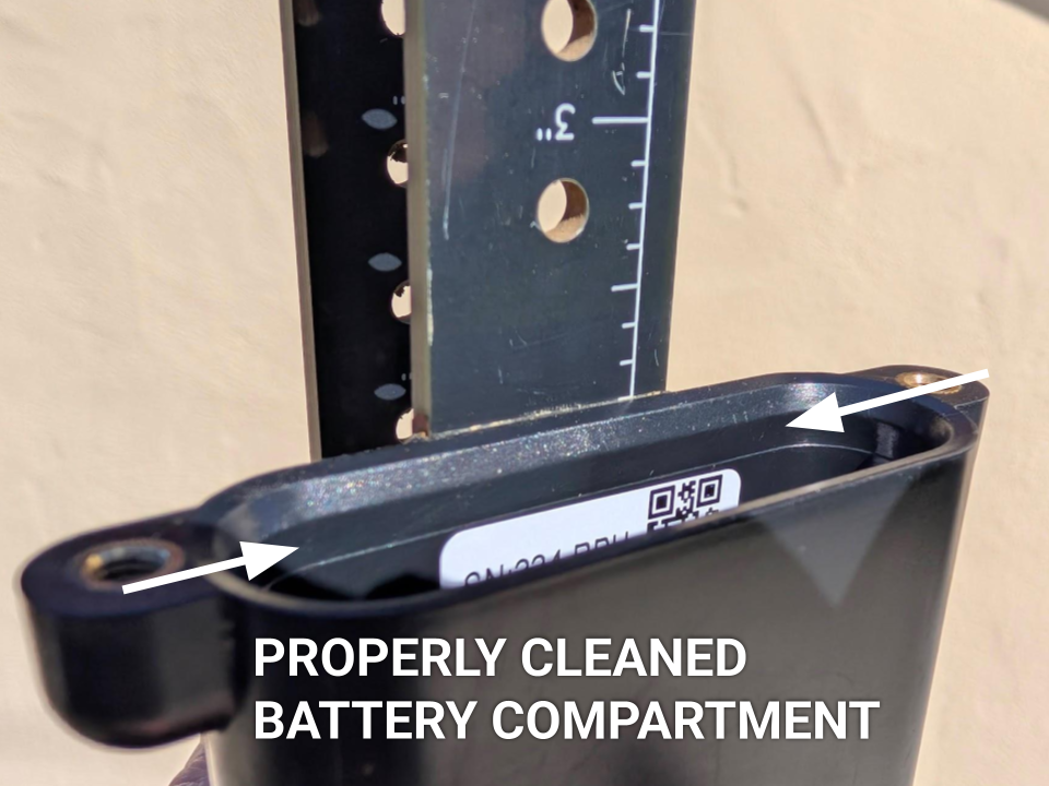 A view looking directly into the empty battery compartment, now spotlessly clean free of debris
