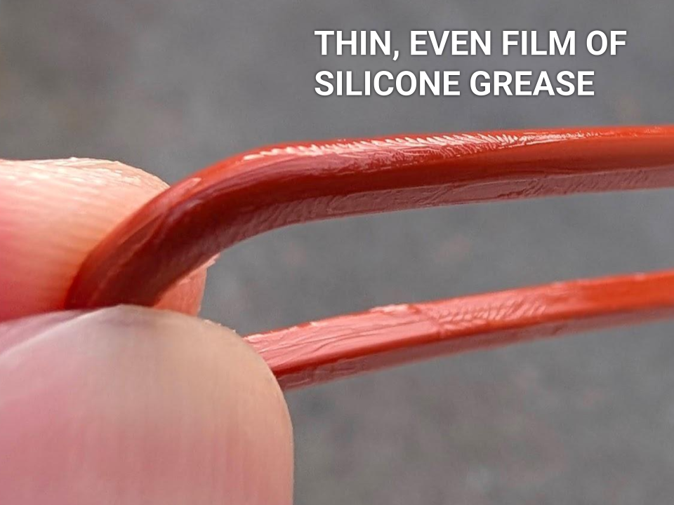 A detailed macro shot of O-ring after the lubricant has been fully spread, showing a uniform glossy sheen and a distinct 